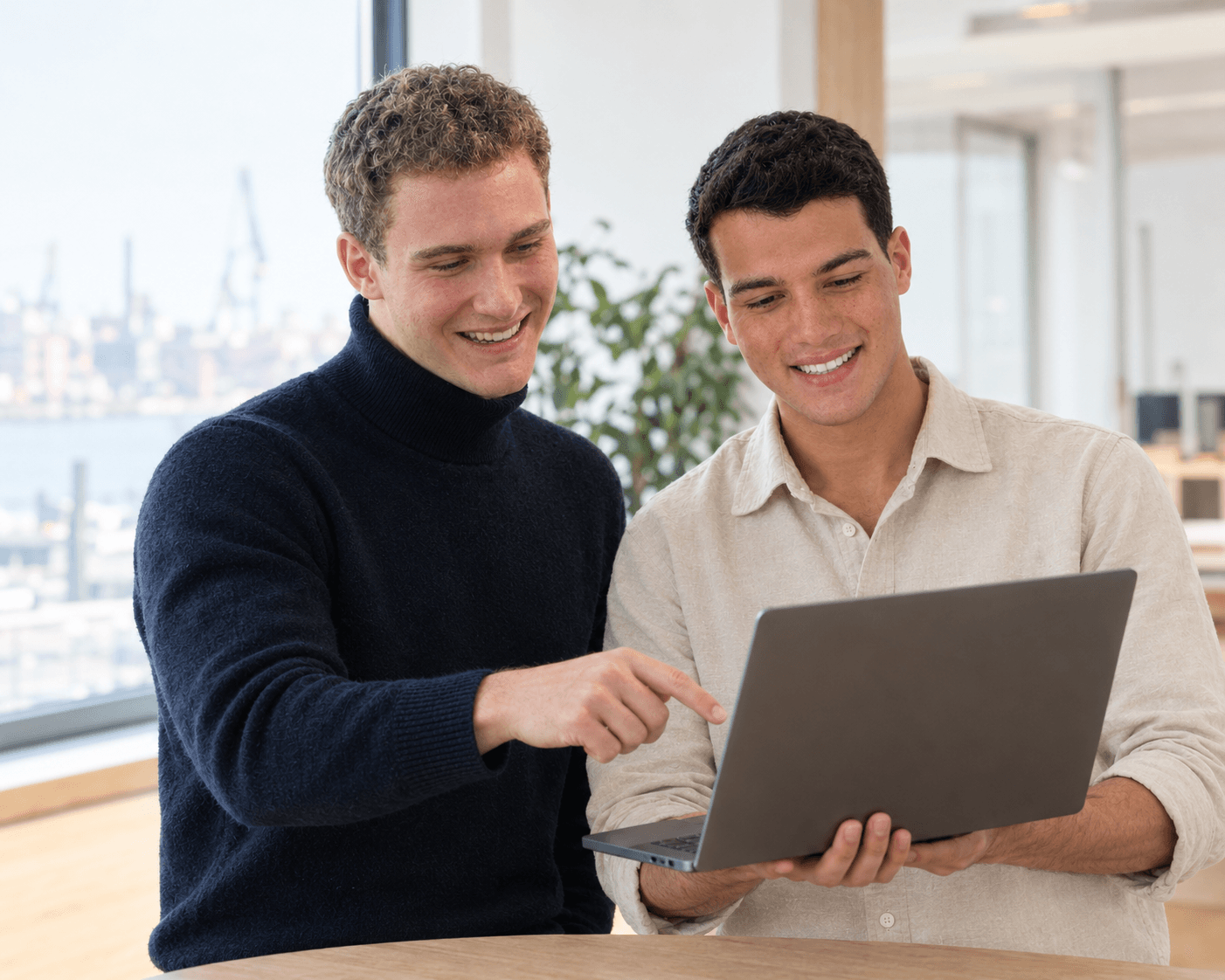 Konrad Kindermann und Kerem Özen schauen gemeinsam auf einen Laptop
